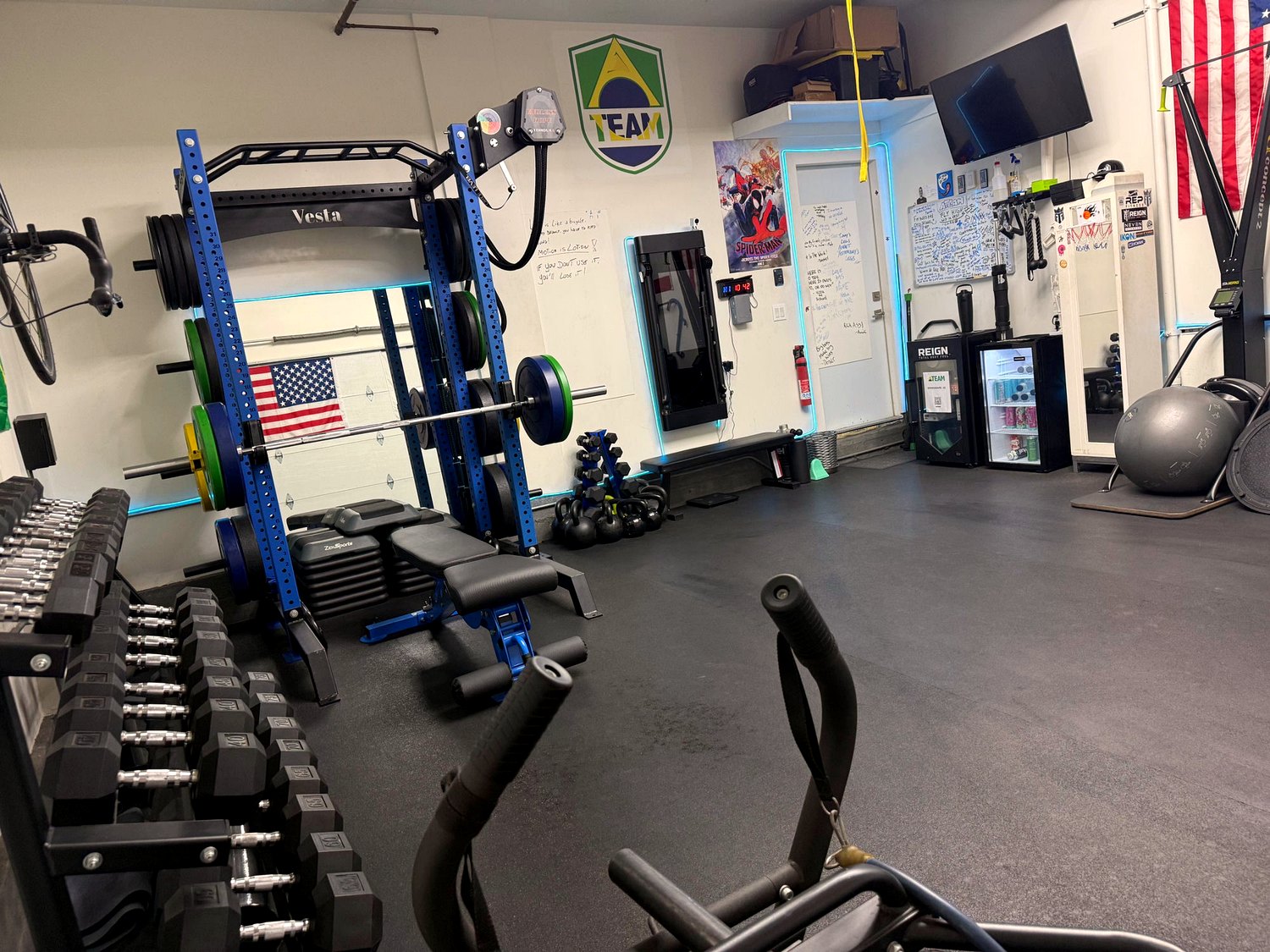 Squat rack with US flag and ATeam logo on the wall